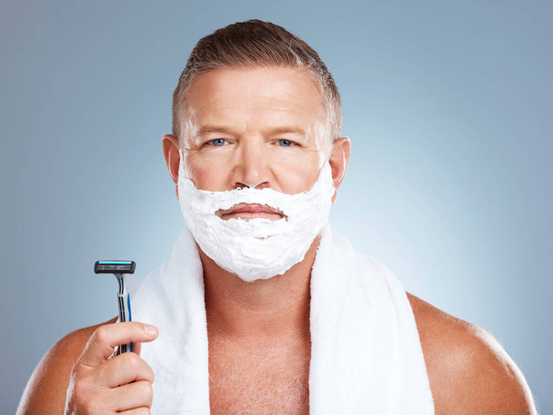 Portrait, razor and old man shaving in studio with foam, skincare or beauty on grey background. Face, blade and mature male model relax for luxury, hair removal and facial, skin and product isolated. - Valokuva, kuva