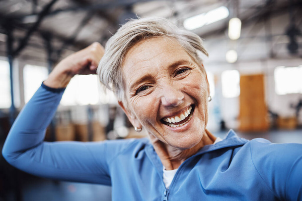 Mujer mayor, flex y sonrisa para selfie o foto de perfil en el ejercicio, entrenamiento o entrenamiento muscular en el gimnasio. Retrato de cara femenina feliz anciana en forma sonriente para vlog, redes sociales o post. - Foto, Imagen