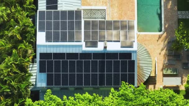 Widok z lotu ptaka drogiego amerykańskiego dachu budynku z niebieskimi panelami fotowoltaicznymi do produkcji czystej ekologicznej energii elektrycznej. Inwestowanie w odnawialną energię elektryczną na potrzeby koncepcji dochodu emerytalnego. - Materiał filmowy, wideo