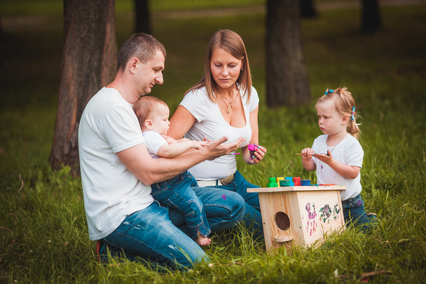 Happy family with nesting box and paints - Фото, изображение