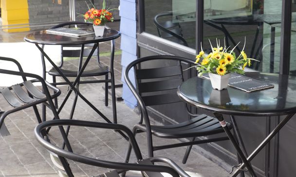 μαύρη καρέκλα και ένα τραπέζι στο υπαίθριο καφέ - Φωτογραφία, εικόνα