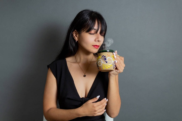 latin woman drinking mexican coffee in traditional cup - Foto, imagen