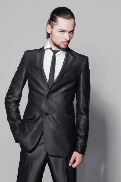 Stylish man with long hair in elegant black suit - Foto, imagen