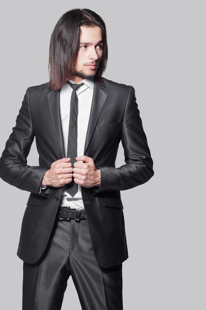 Stylish man with long hair in elegant black suit - Foto, Imagen