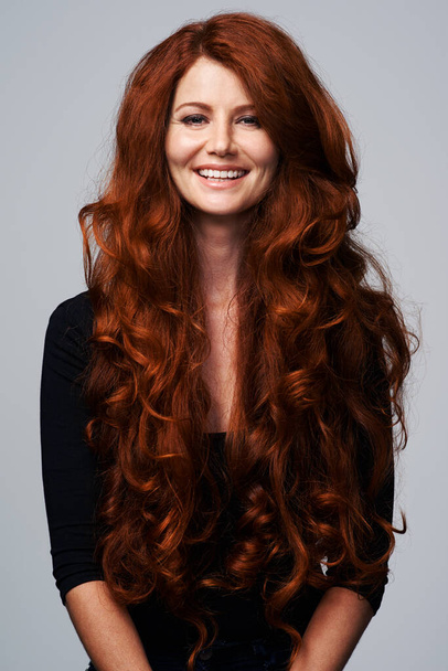 Teşekkürler, kendim yetiştiriyorum. Gri bir arka planda poz veren güzel kızıl saçlı genç bir kadının stüdyo fotoğrafı. - Fotoğraf, Görsel