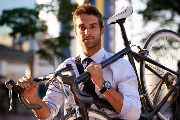 Yeşil yolu seçiyorum. İşe giderken bisikletini taşıyan çekici bir genç adam. - Fotoğraf, Görsel