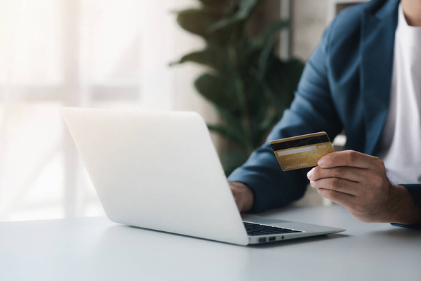 Person holding a credit card, uses a credit card to pay for goods and services online, the concept of using a credit card for online shopping, ordering goods and services on the website. - Photo, Image