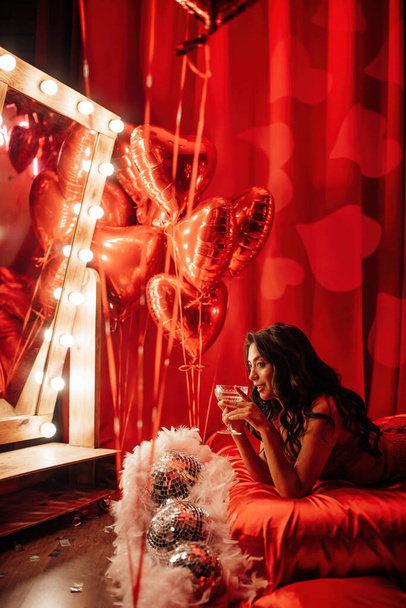 Beautiful asian model with champagne glass posing in bed on Valentine's day - Zdjęcie, obraz
