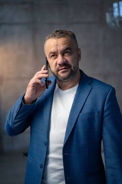 Retrato de un joven y apuesto hombre de negocios hablando por teléfono. Foto de alta calidad - Foto, Imagen