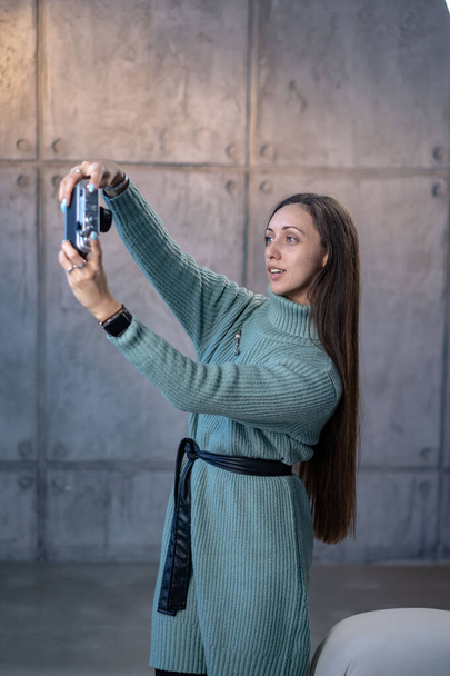 Smiling young woman taking photo of herself against . High quality photo - Foto, Bild