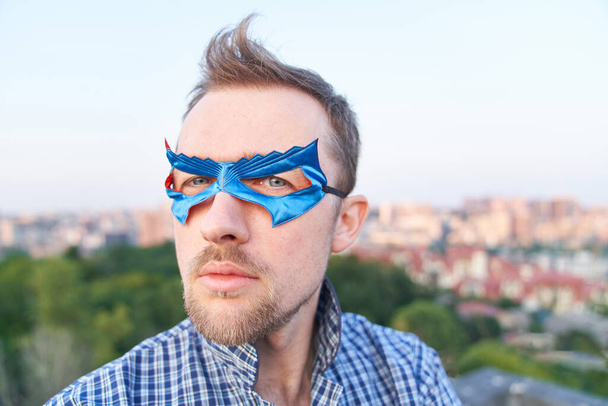 serious caucasian man in nightwear shirt and superhero blue mask looking at side with serious face. Superpower or funny concept. High quality image - Zdjęcie, obraz