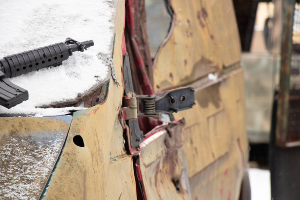 A plastic childrens pistol lies on a military vehicle wrecked on the street in Ukraine in winter, the war in Ukraine - Photo, Image