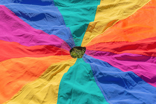 Діти грають на парашуті для навчання на відкритому повітрі. Веселкові кольори тканинна іграшка для дитячих ігор розвитку
 - Фото, зображення
