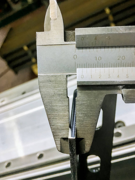 Measuring the thickness of sheet metal with a caliper. Measurement accuracy. The thickness of the metal is 3 mm. - Valokuva, kuva