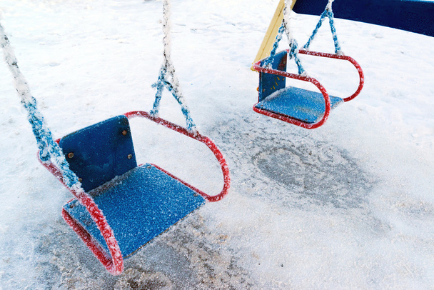 snow covered swing and slide at playground in winter - Fotografie, Obrázek