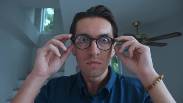 Scared man takes off his glasses and is frightened by what he sees. Portrait of scared young 30 millennial man. Business man takes off glasses in fright and covers his mouth, scared by bad news. - Metraje, vídeo