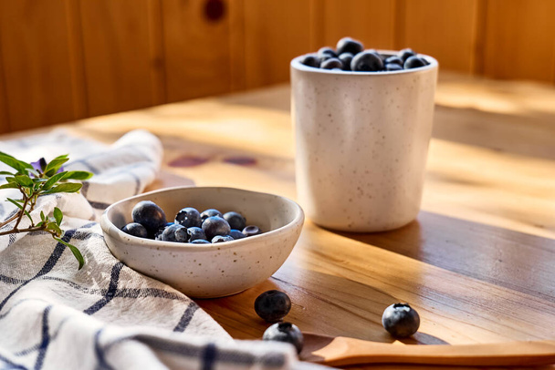 Fresh organic blueberries. Juicy ripe bilberry in white bowl on wooden table. Antioxidant and healthy eating concept. - Fotografie, Obrázek