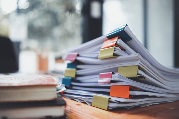 The stacks of documents lying on the desk are waiting to be verified before being sent to the Board of Directors to use the correct information before meeting with businessmen and investors. - Foto, Imagen