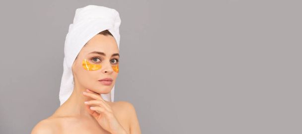 beautiful girl with terry towel use facial golden eye patch for skin, healthy skin. Beautiful woman isolated face portrait, banner with mock up copy space - Foto, afbeelding