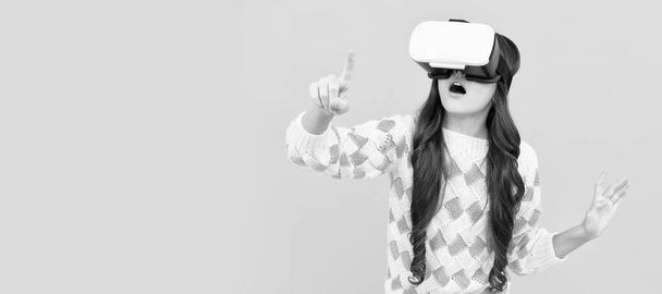 verbaasd tiener meisje dragen vr bril met behulp van technologie voor onderwijs in virtual reality, virtual world. Banner van kind meisje met virtual reality vr headset, studio portret met kopieerruimte - Foto, afbeelding