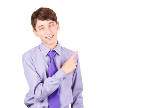 Pointing your product. Portrait of handsome teen boy in shirt and tie pointing copy space and smiling isolated on white background - Fotografie, Obrázek