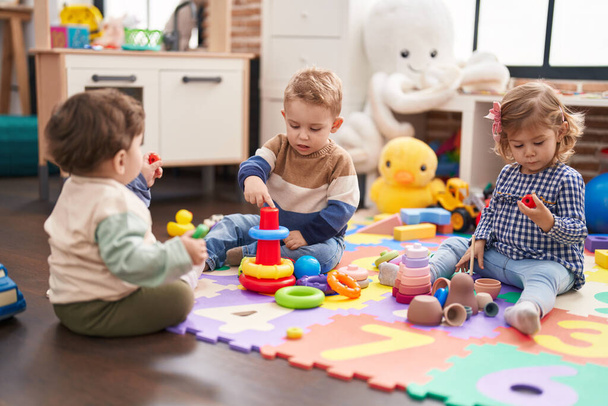 Group of kids playing with hoops toys sitting on floor at kindergarten - Φωτογραφία, εικόνα