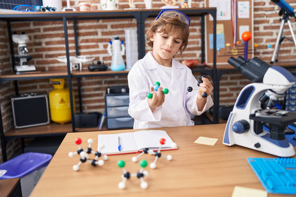 Uroczy biały chłopiec student trzyma molekuły w klasie - Zdjęcie, obraz