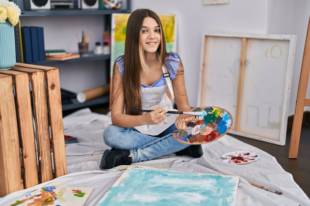 Чарівна дівчина художник посміхається впевнений малюнок в художній студії
 - Фото, зображення