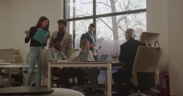 Multiracionális munkavállalók csoportja, akik egy modern üzleti irodában dolgoznak együtt - Felvétel, videó