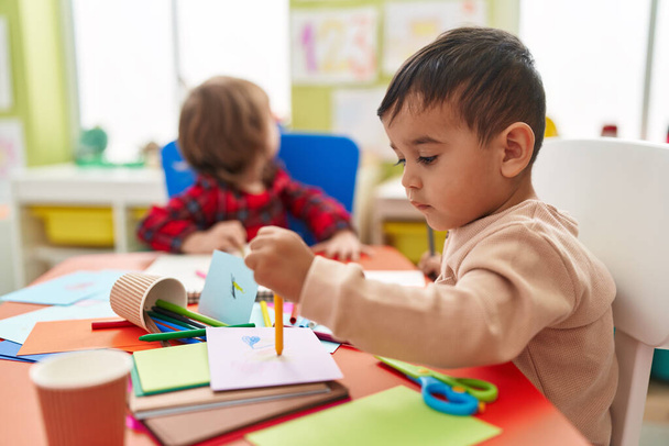 Two kids preschool students sitting on table drawing on paper at kindergarten - Fotografie, Obrázek