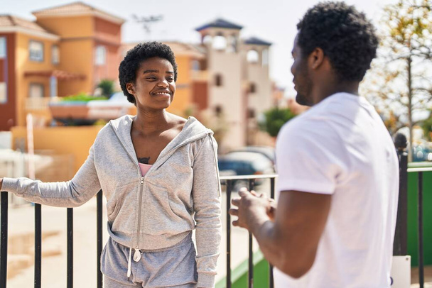Afrykański Amerykanin mężczyzna i kobieta para rozmawiający razem na ulicy - Zdjęcie, obraz