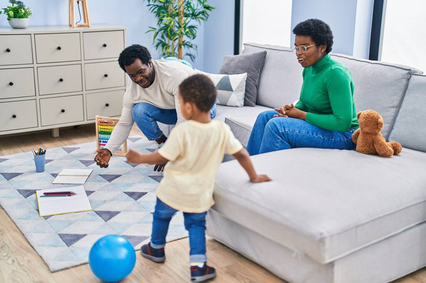 Familia afroamericana jugando con pelota en casa - Foto, Imagen