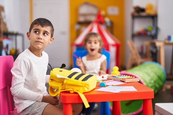 Irmão e irmã estudantes sentados na mesa desenho em papel no jardim de infância - Foto, Imagem