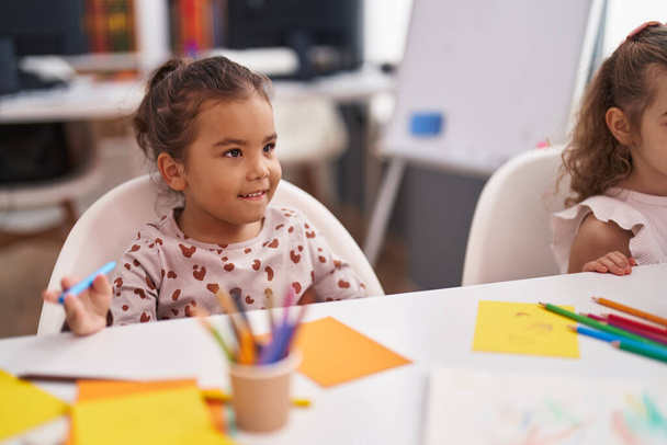 Two kids preschool students sitting on table drawing on paper at classroom - Zdjęcie, obraz