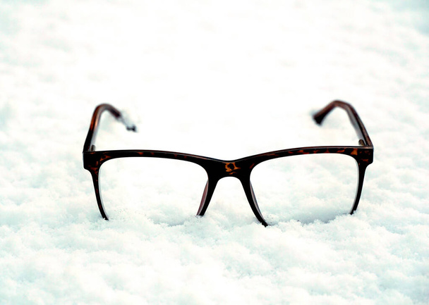 trendy glasses lie on the snow. winter theme concept. - Foto, Imagen