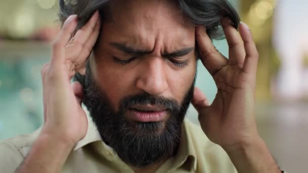 Portrait Arabian sad ill sick unhappy man unhealthy guy massaging temples with painful headache. Depressed Indian ethnic businessman bearded male suffering from migraine high blood pressure pain ache - Filmagem, Vídeo