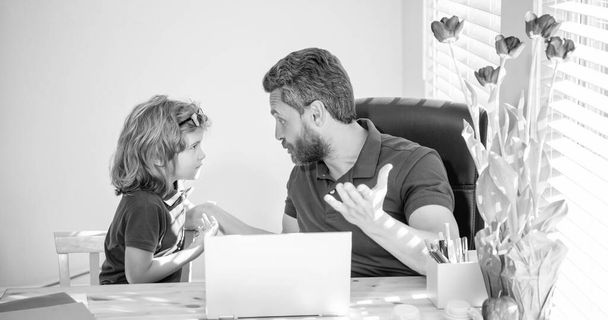 bearded dad or school private tutor teaching boy son with modern laptop, parenting. - 写真・画像