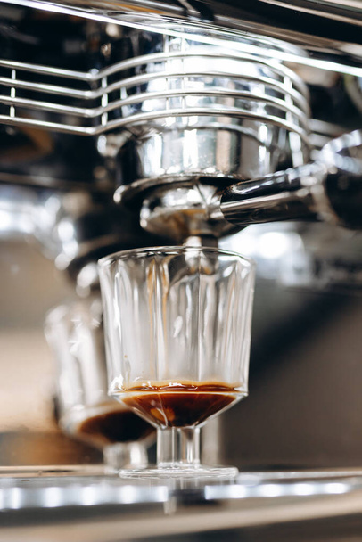 Kahve makinesi dipsiz iskeleden taze espresso hazırlıyor. Kahve çıkarma. Güzel kremalı nefis bir sabah kahvesi. Kahve dükkanı konsepti. - Fotoğraf, Görsel
