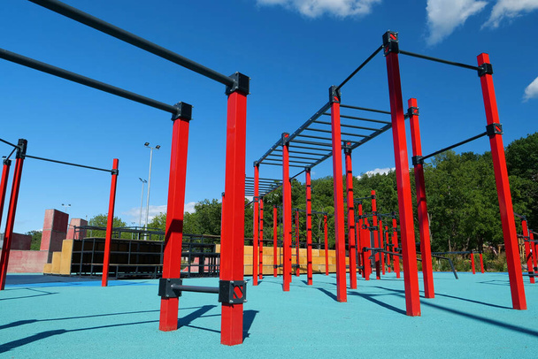 Sportterrein met horizontale balken en andere nieuwe fitnessapparatuur in de openluchtsportzone in de stad. Sportveld voor lichaamsbeweging in de open lucht - Foto, afbeelding