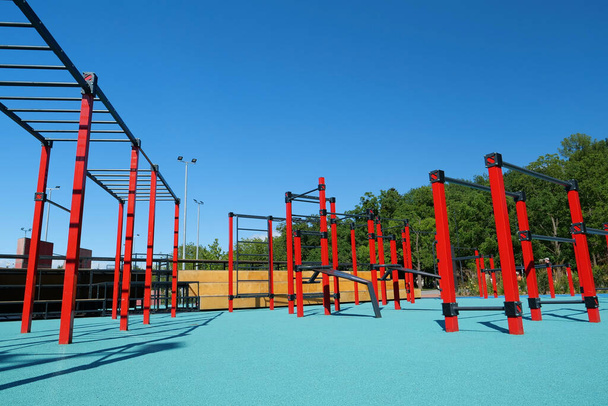 Sports ground with horizontal bars and other new exercise equipment in open air sport zone in the city. Sports ground for physical exercise on open air - Photo, Image