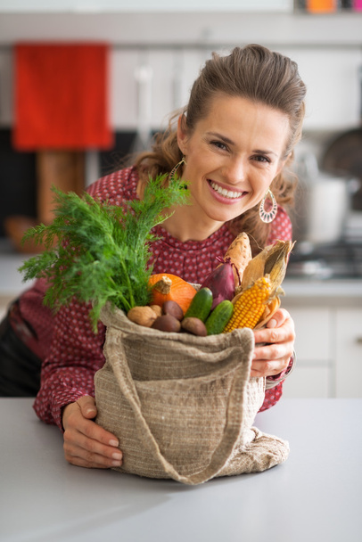 Portrait of smiling young housewife with vegetables from local m - Φωτογραφία, εικόνα