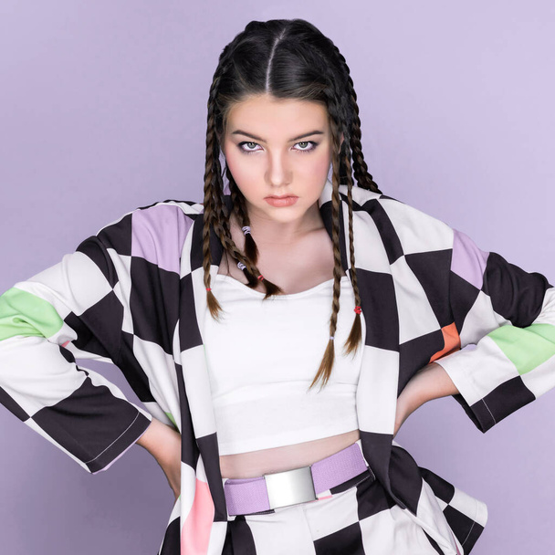 Closeup beautiful young girl with perfect skin, cosmetic and long braid posing with trendy fashion outfit in the studio with isolated background. charming young teenage with beauty gesture. - Foto, imagen