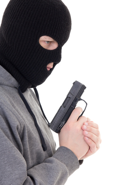 Zobacz Profil karnego człowieka w masce trzymając pistolet na białym tle na whi - Zdjęcie, obraz