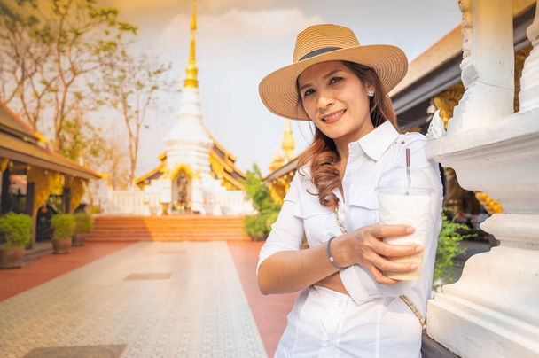 Donna asiatica con Wat Phra That Doi Phra Chan sfondo, provincia di Lampang. - Foto, immagini