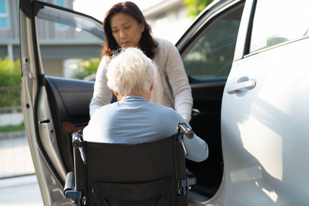 Азиатская пожилая или пожилая старуха пациентка, сидя на инвалидной коляске подготовить добраться до ее автомобиля, здоровый сильный медицинский концепт. - Фото, изображение