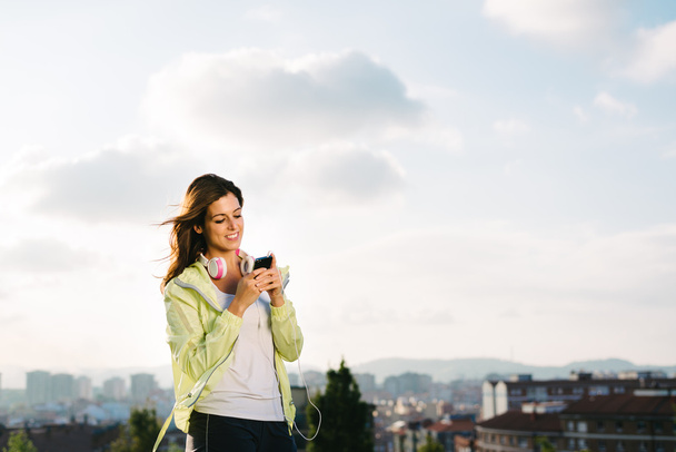 Female athlete with smartphone messaging - Photo, Image