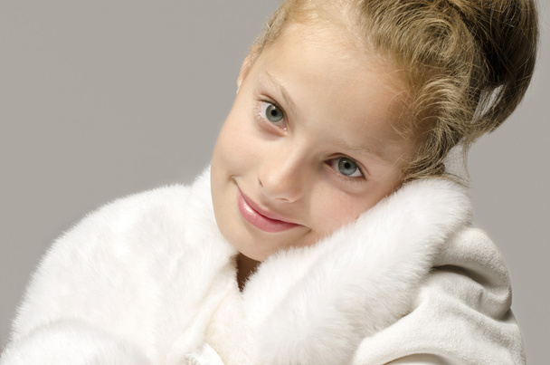Girl wearing a white long coat and looking like snow white, beautiful kid worming up in for the winter time - Foto, imagen