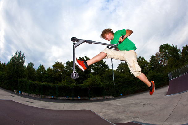 Junge springt mit seinem Roller in die Luft - Foto, Bild