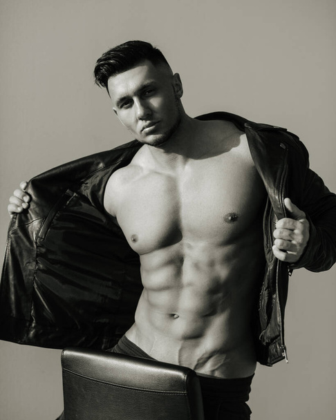 Black and white portrait of handsome man in leather jacket. Sexy male model in brutal look. Biker style shot of muscular guy. - Foto, Imagen