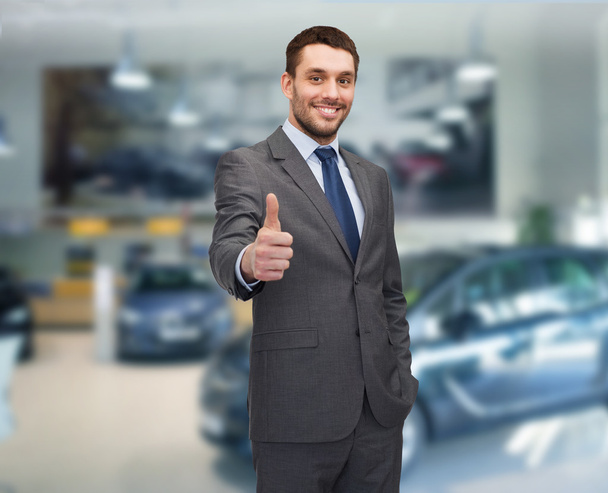 smiling businessman showing thumbs up - Photo, image